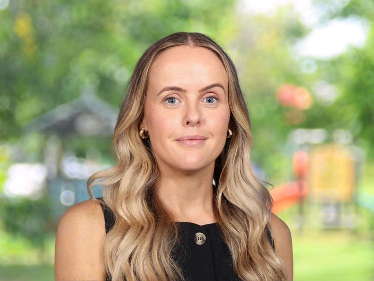 Emma Pons wearing black sleeveless top in front of blurred school playground